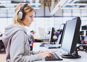 UB英语语言学院的学生在电脑上戴着耳机